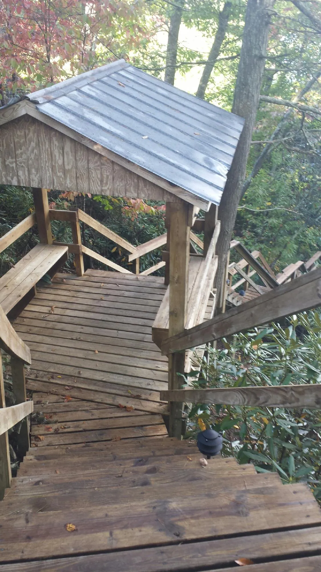 Metal roofed shelter over wooden steps on a wooded walkway — Skylight Repair & Installation work by our crew in Severn
