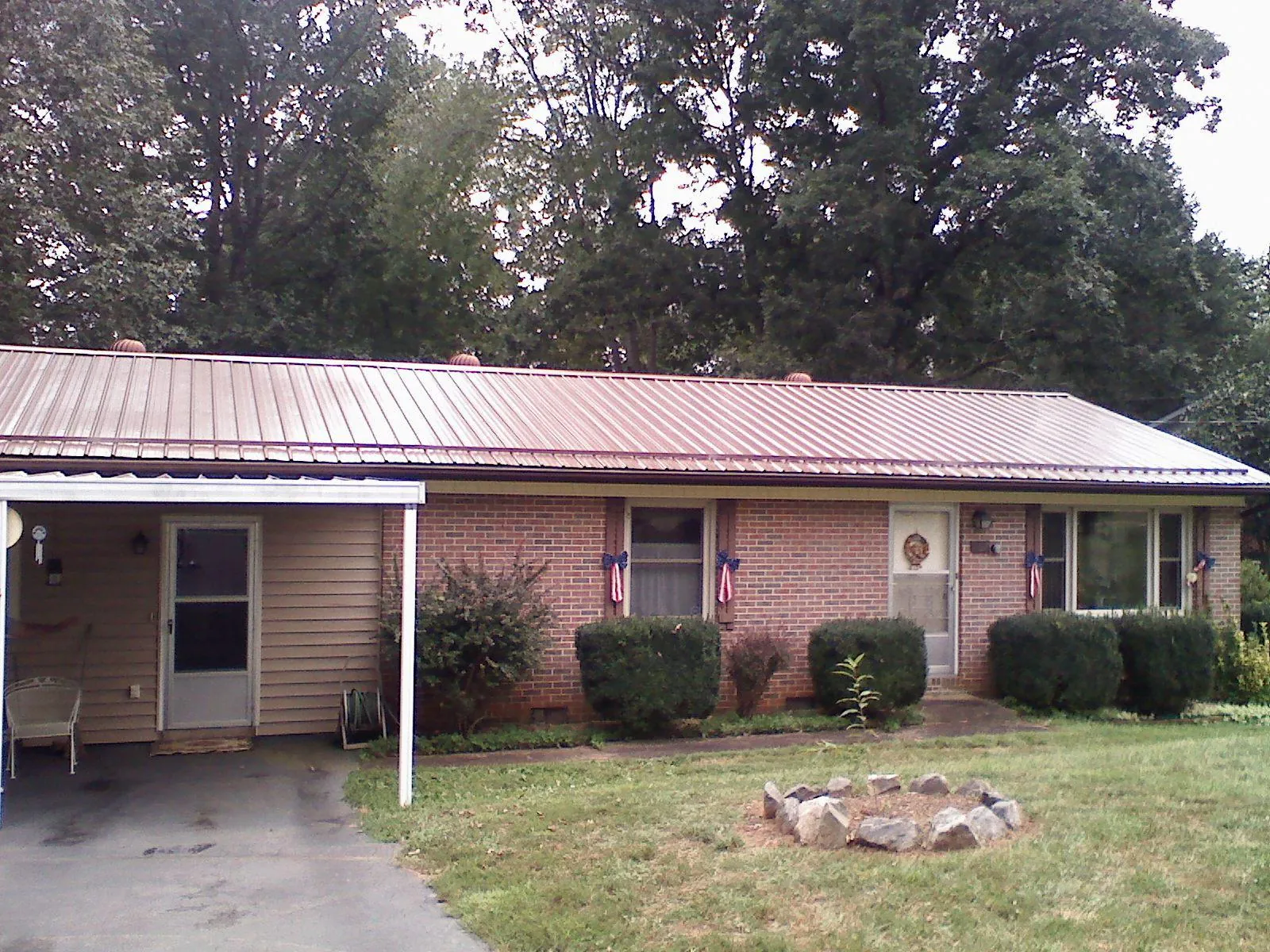 Bronze metal roof and carport on a brick ranch home — Roof Repair work by our crew in Severn